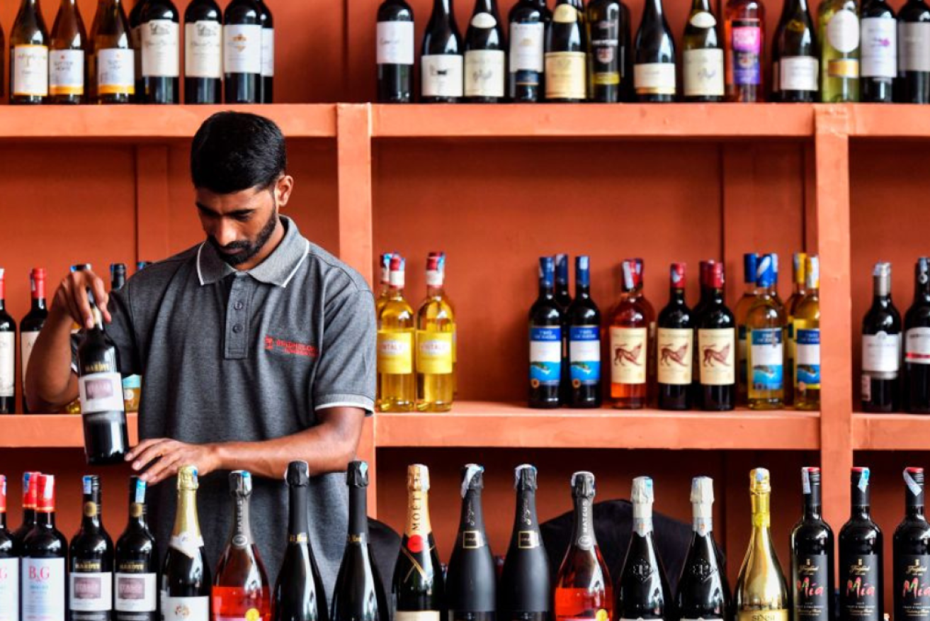 A vendor arranges wine bottles at the Fourth International Wine Festival in Bengaluru.