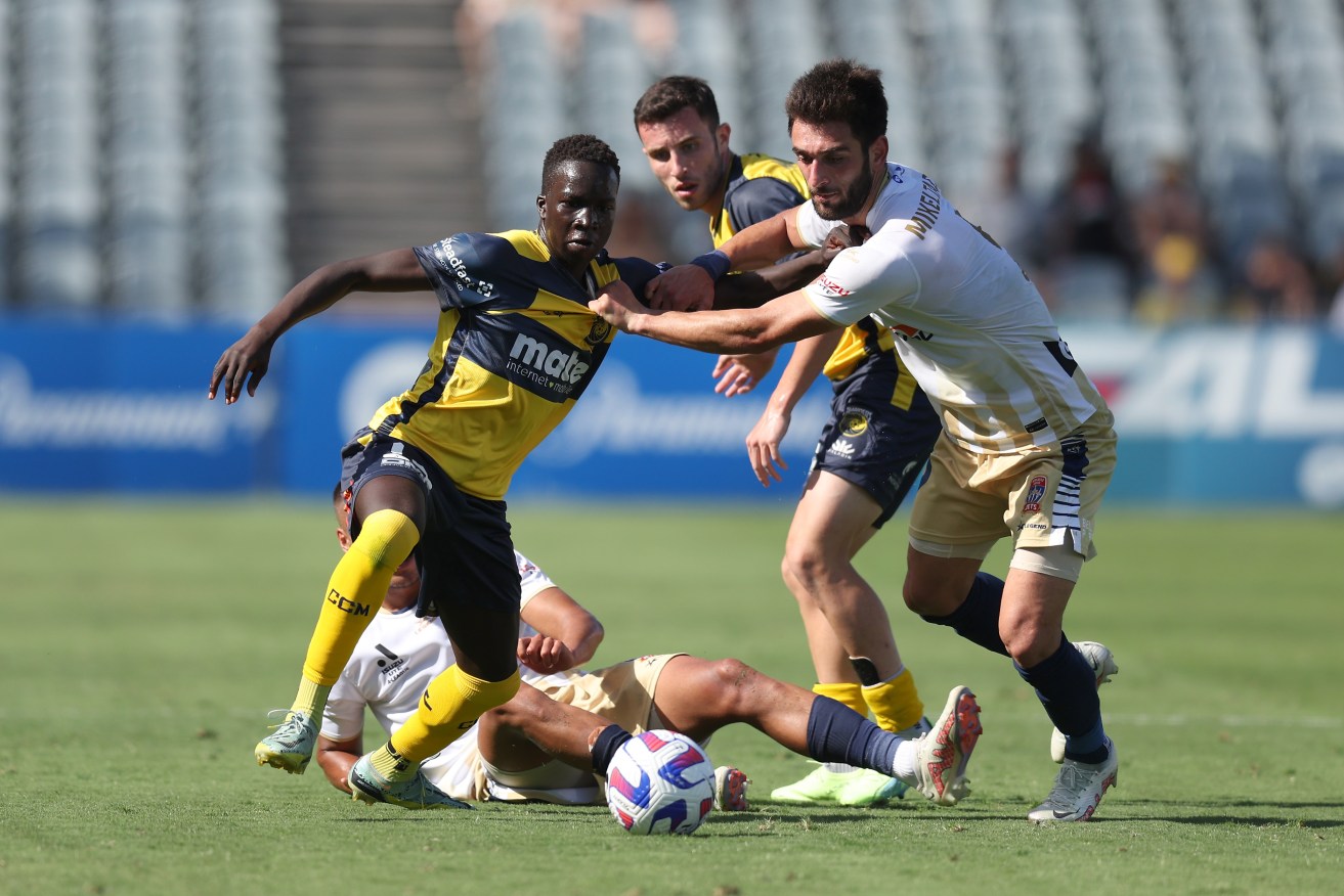 Garang Kuol of the Mariners competes for the ball with Newcastle's Beka Mikeltadze in Gosford. 