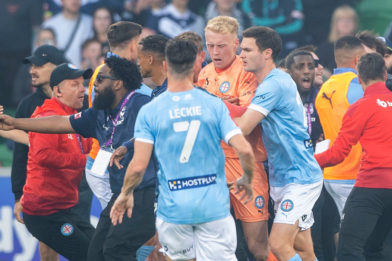 Tom Glover of Melbourne City is escorted from the pitch during the A-League Men's derby.