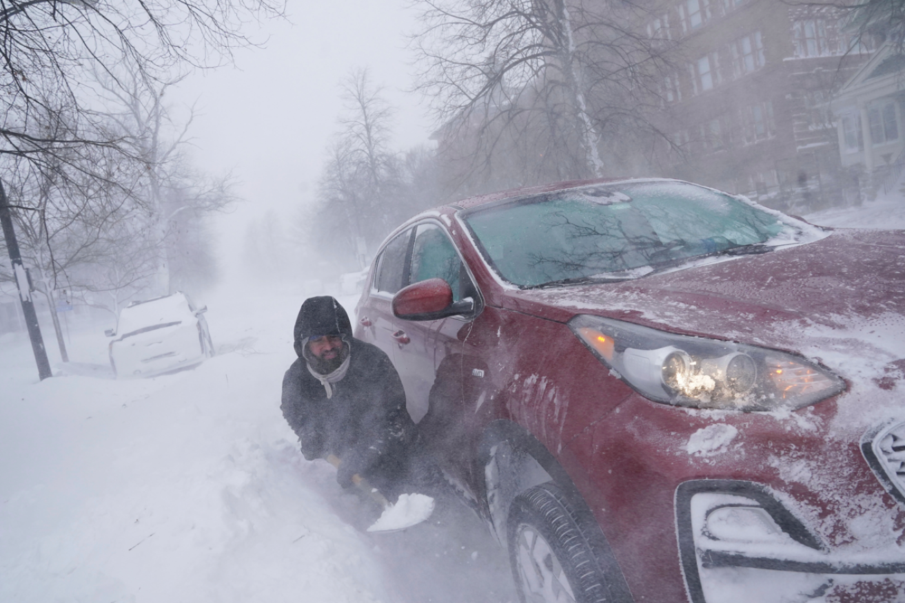 Everyone wants a white Christmas - until it actually happens, like this motorist digging his car out of a snow drift in New York. <i>Photo: AP</i>