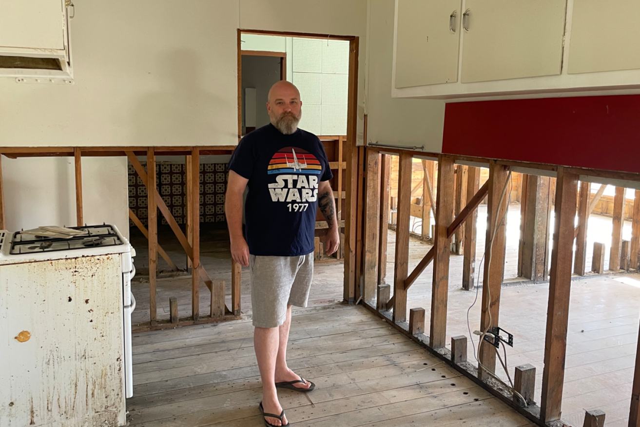 Leigh Wilson surveys what is left of the family home in Victoria's flood-ravaged Rochester. <i>Photo: AAP</i> in his childhood home in Rochester