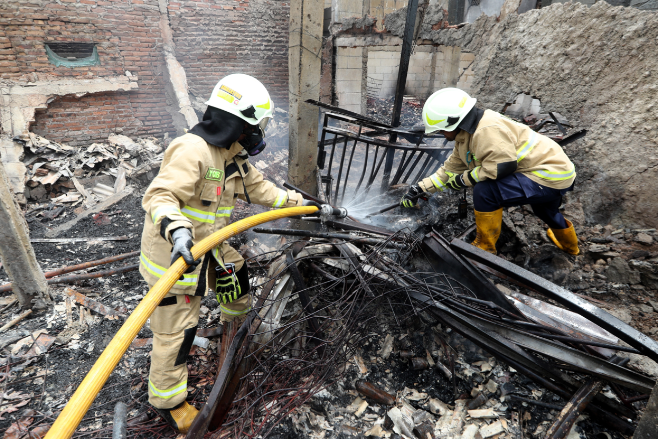 Indonesian emergency workers make sure the horrific blast's last flames  are definitely out. <i>Photo: EPA</i>