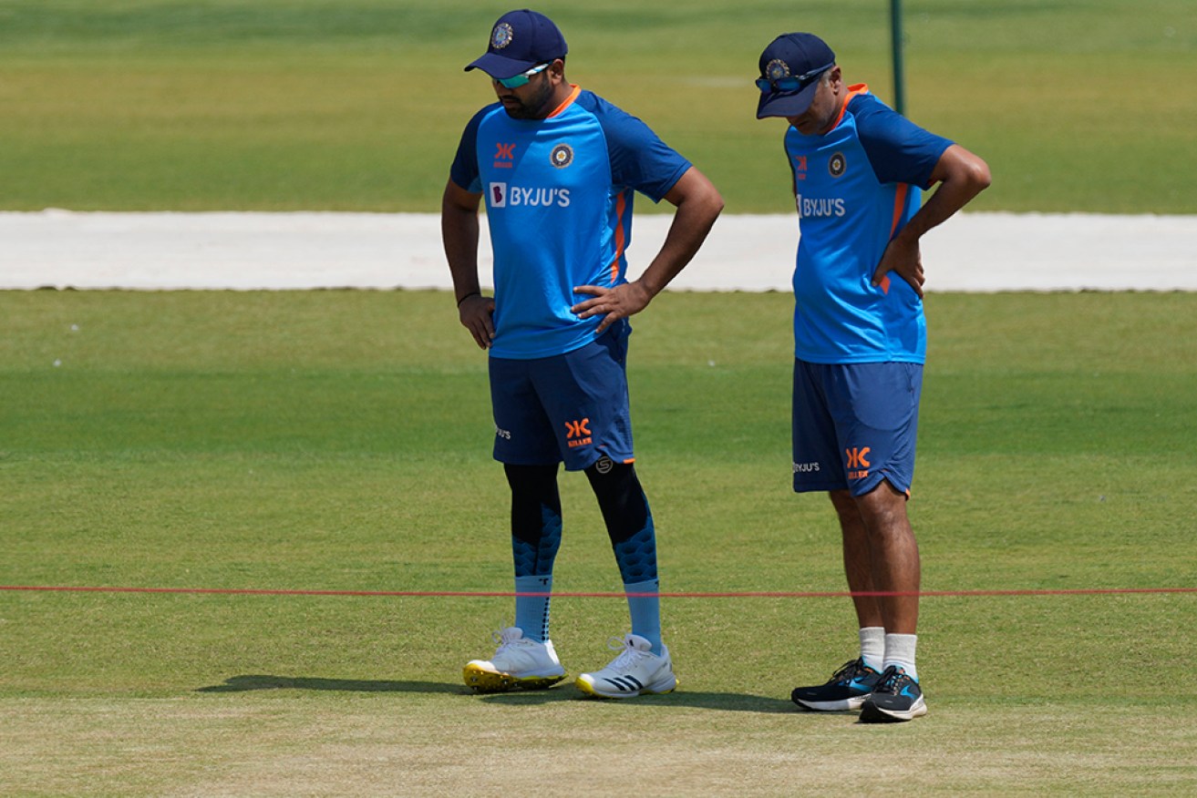 Indian captain Rohit Sharma and coach Rahul Dravid study the potential Test wicket in Ahmedabad.