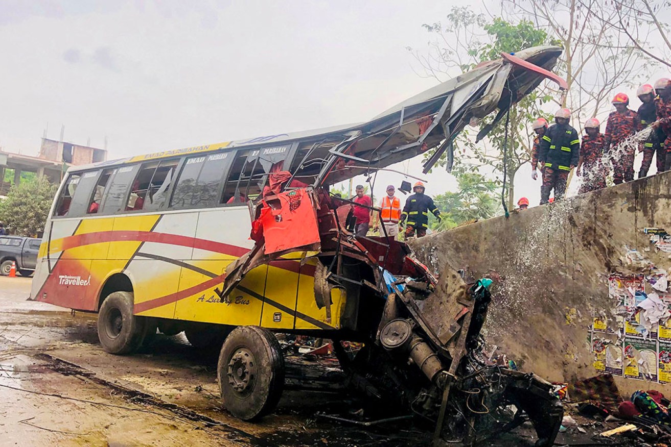 Firefighters extinguish a fire in the crashed bus at Madaripur on Sunday. 