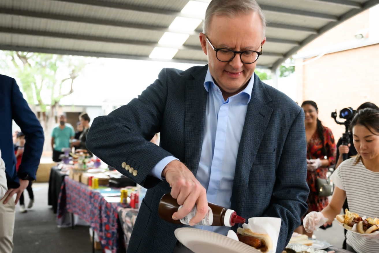 PM Albanese honours a great election day tradition and tucks into his democracy sausage in Ryde. <i>Photo: AAP</i>