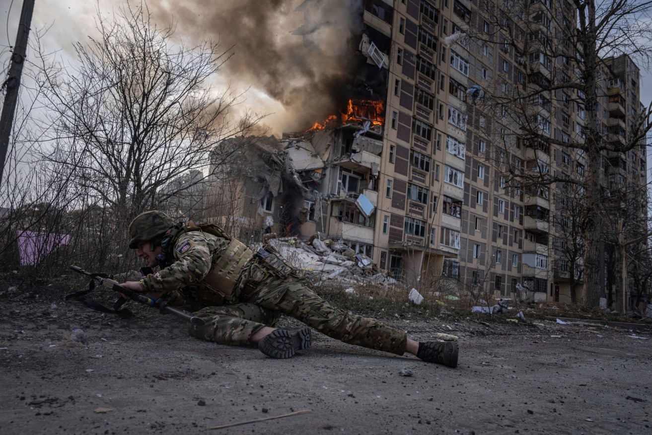 A Ukrainian police officer takes cover during shelling of Avdiivka, Ukraine, by Russian forces.
