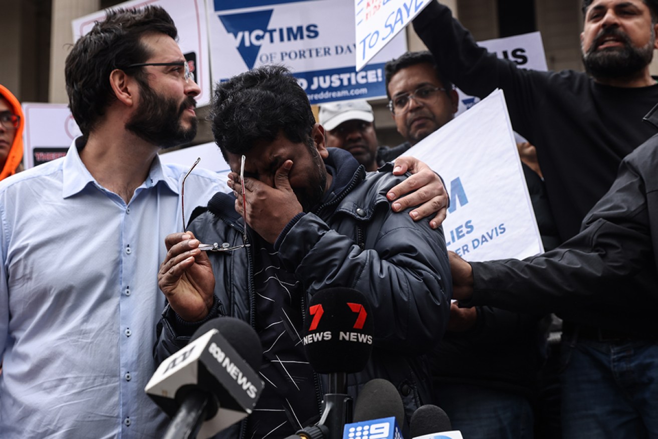 Anil Venul (centre) is overcome with emotion at a protest over the collapse of builder Porter Davis. 