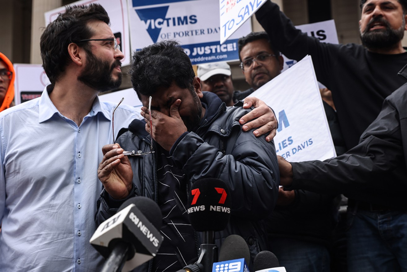 Anil Venul (centre) is overcome with emotion at a protest over the collapse of builder Porter Davis.