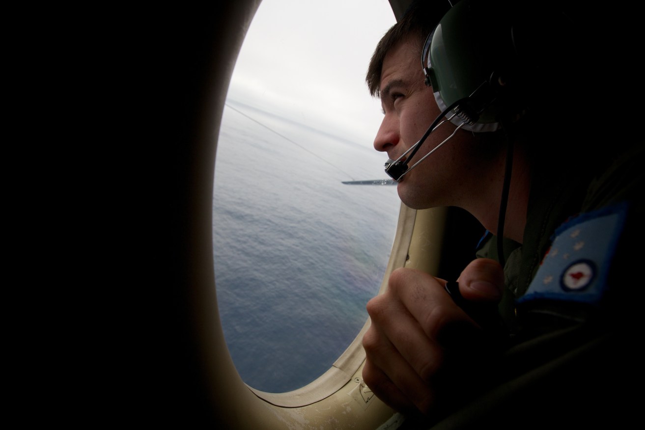 **FILE** A March 24, 2014 file photo of a crewman of an RAAF AP-3C Orion aircraft looking out his observation window whilst searching for missing Malaysia Airways Flight MH370. The search of missing Malaysia Airlines flight MH370 has been called off. In a statement on Tuesday, transport ministers from Australia, Malaysia and China confirmed the underwater search in the southern Indian Ocean has been suspended until there is any new credible evidence. (AAP Image/Richard Wainwright) NO ARCHIVING