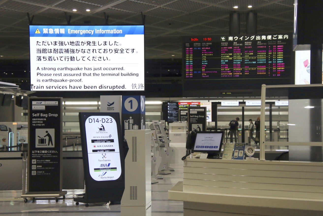 An electronic message board at Narita International Airport in Narita, east of Tokyo, shows notice of an earthquake that occurred on Friday.
