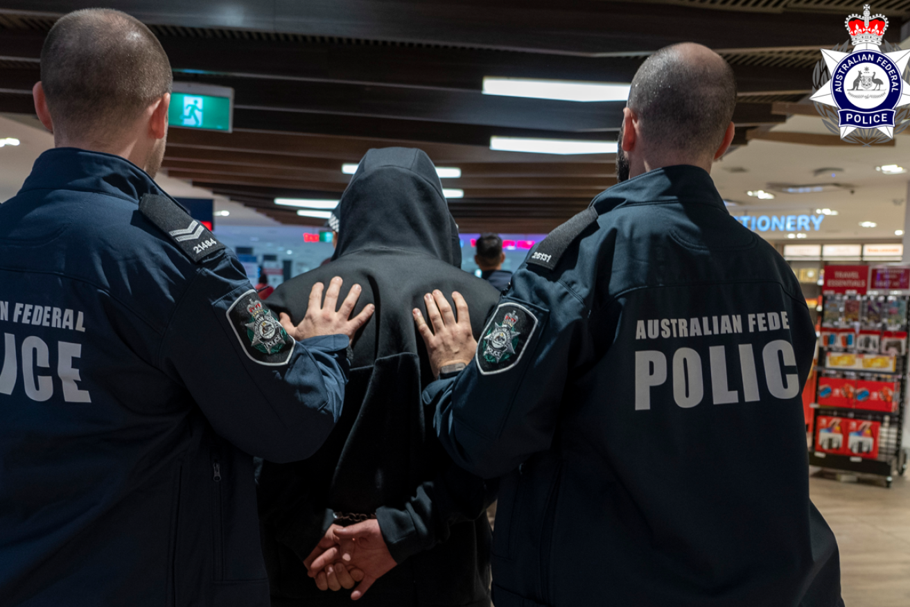 AFP officers lead a handcuffed Guy Habkouk through Sydney Airport after his deportation from Turkey.