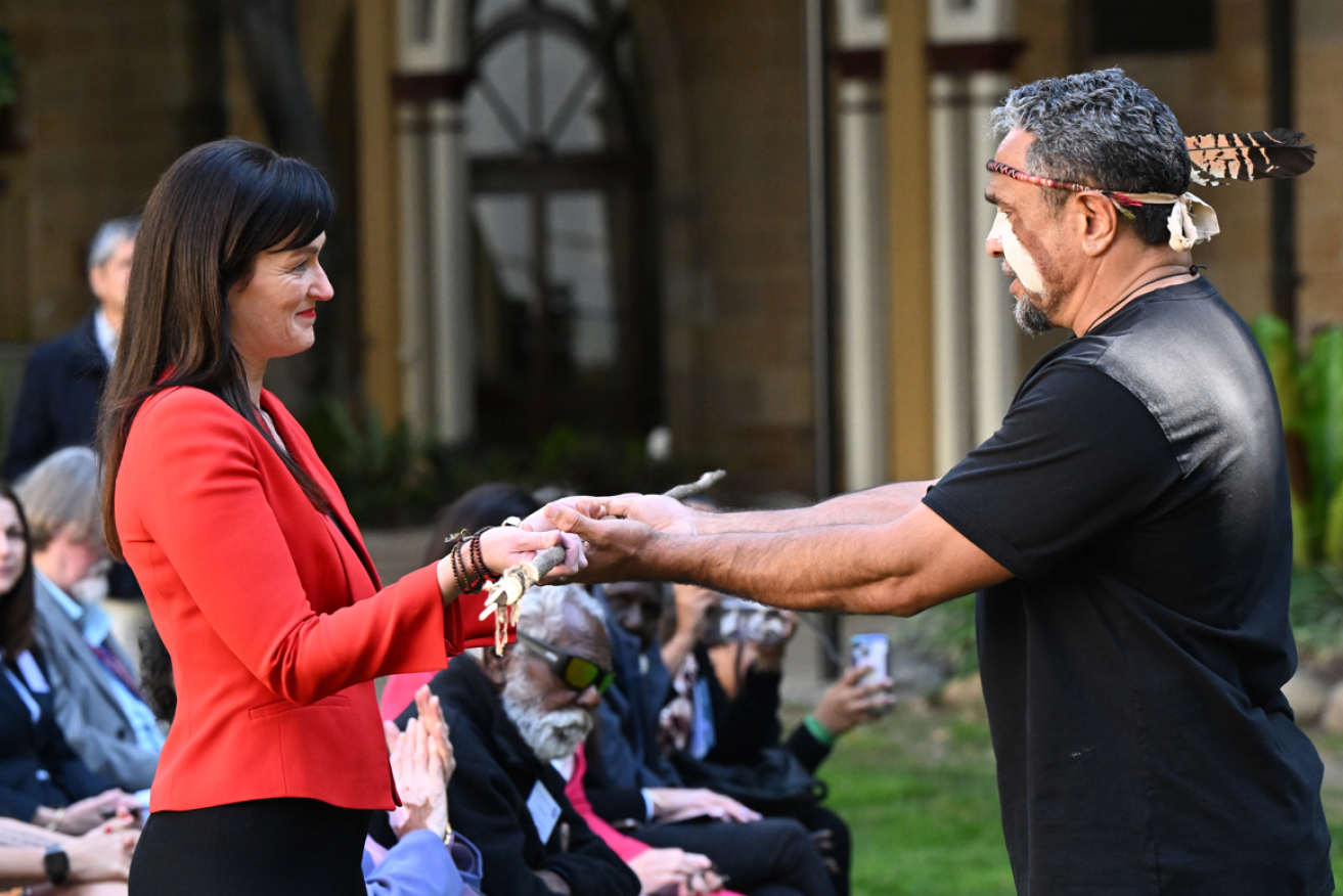 Waanyi traditional owner Alec Doomadgee (right) hands a traditional weapon to Queensland Environment Minister Leanne Linard as a symbol the accord.
