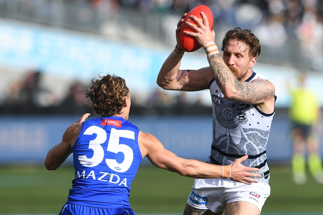 Geelong's Zach Tuohy contests the ball with North's Charlie Lazzaro on Sunday.