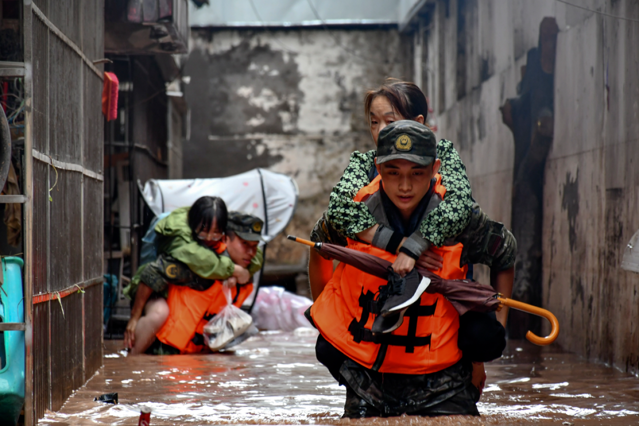 Chinese national police piggyback marooned  Chongqing residents to safety.