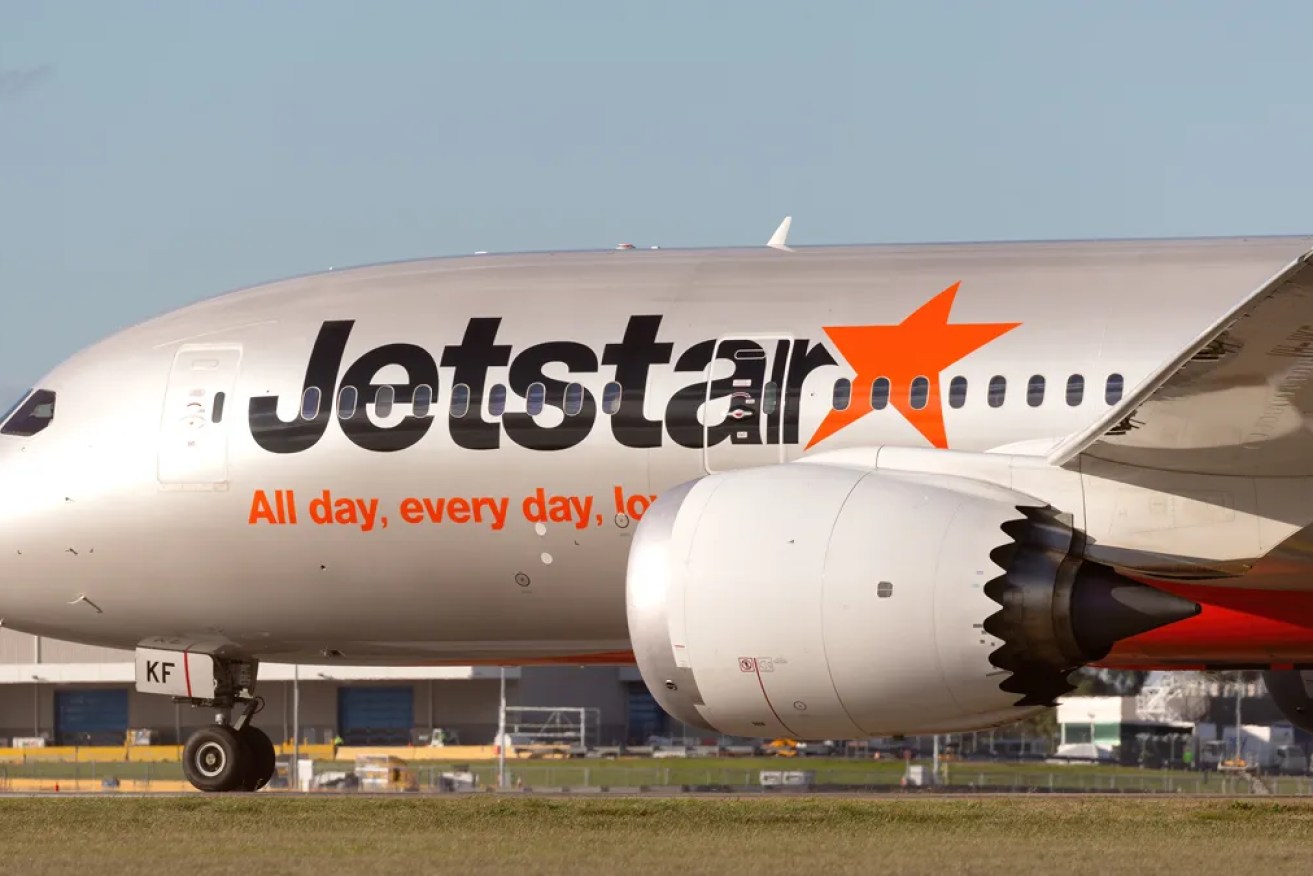 A Jetstar passenger has been arrested after opening the emergency exit after the plane had landed.