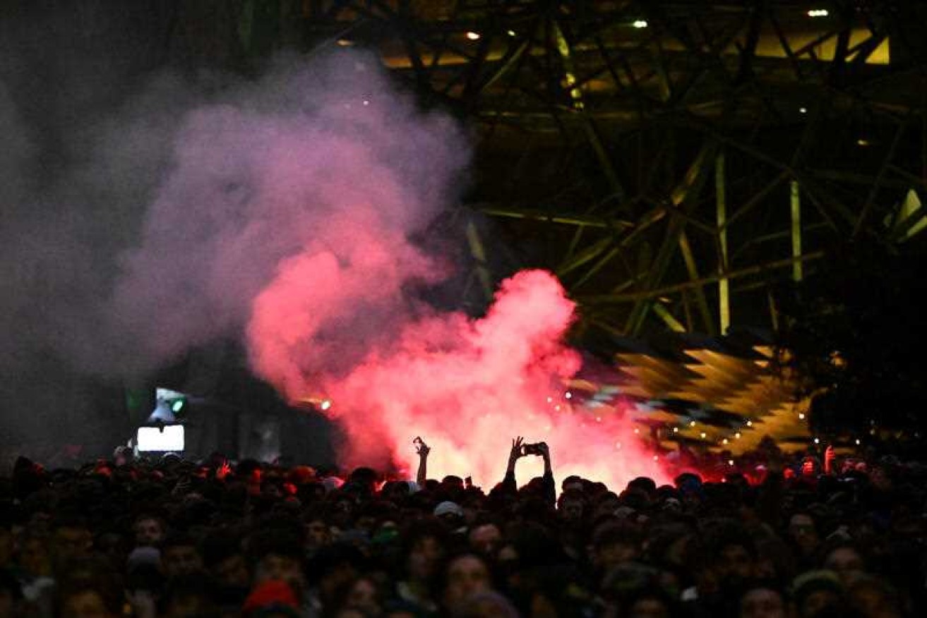 A flare is set off as fans watch the Women's World Cup semi-final in Federation Square, Melbourne.