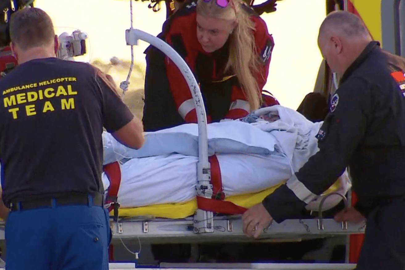 Surfer Toby Begg is rushed from the airvac chopper to Port Macquarie hospital.