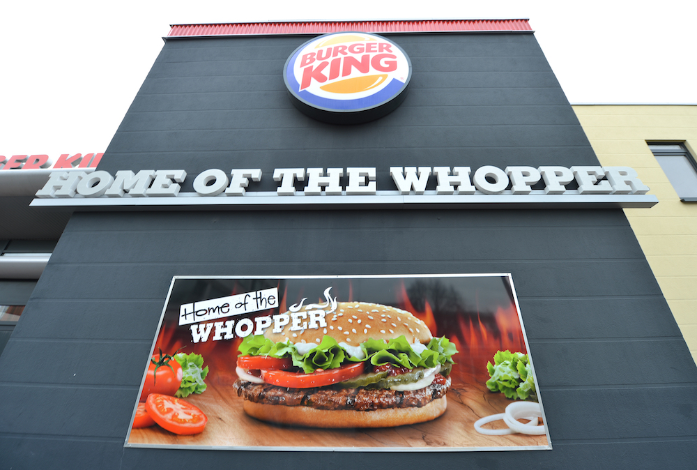 An advertisement reading 'Home of the Whopper is seen at a closed down Burger King restaurant