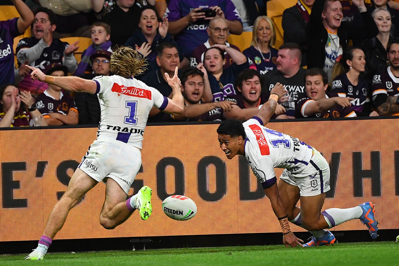 Melbourne’s Ryan Papenhuyzen and Sualauvi Faalogo celebrate the rookie’s first of two tries on Thursday night.