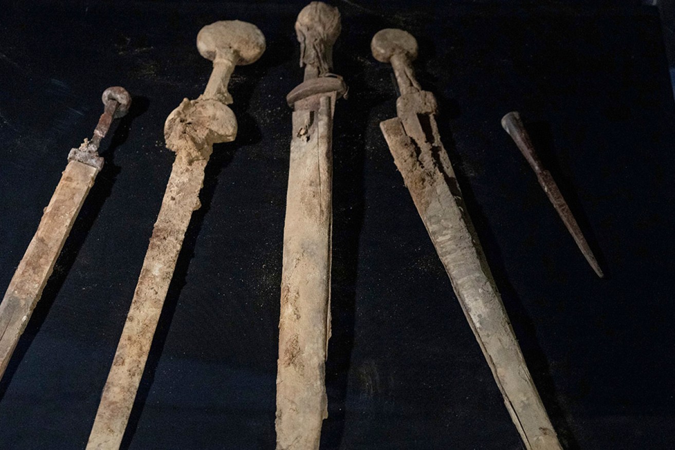 Israeli archaeologists display the Roman-era swords and a javelin head found near the Dead Sea.