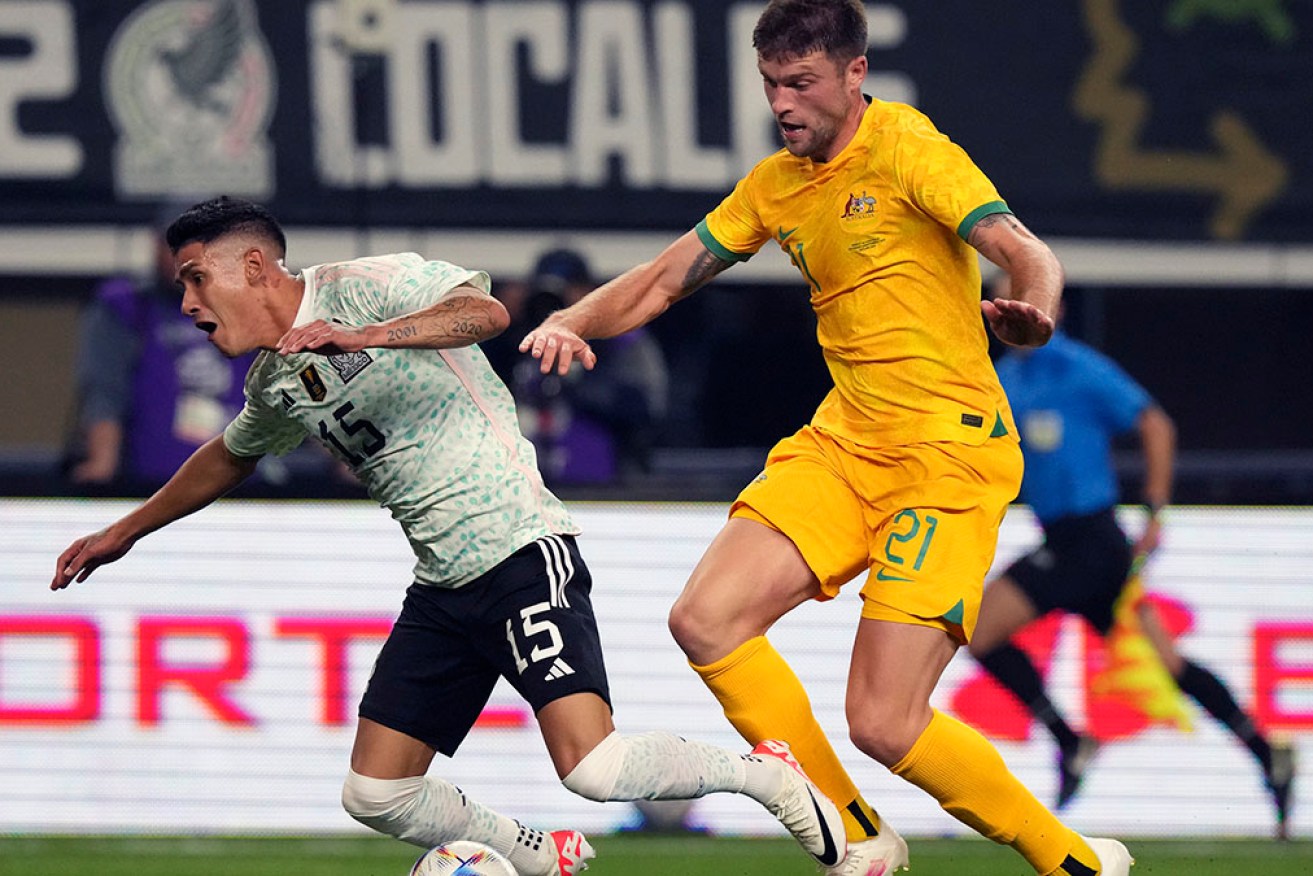 Mexico defender Héctor Moreno is fouled by Australian defender Cameron Burgess on Sunday.