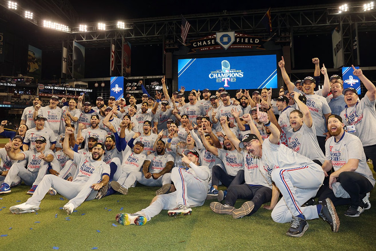Texas Rangers pose for photos after clinching their first World Series at Chase Field in Phoenix on Thursday.
