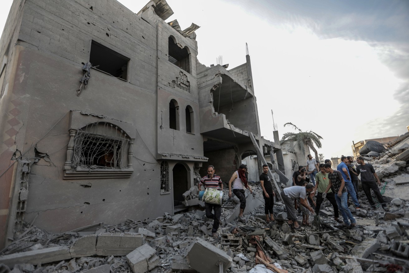 People search through buildings, destroyed during Israeli air strikes in the southern Gaza Strip.