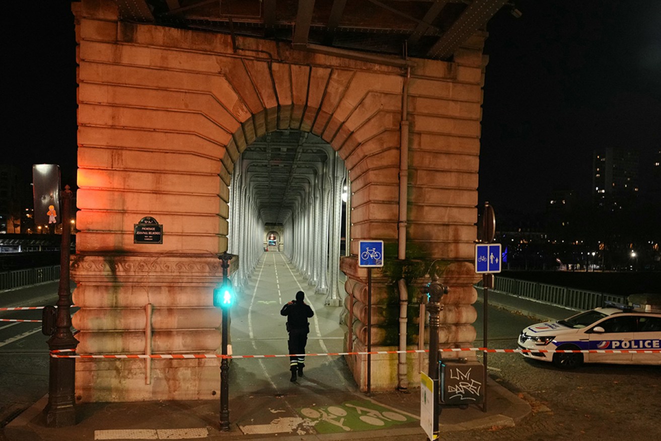 A police officer patrols a security perimeter set after one person was killed and two others wounded in a knife attack in Paris.