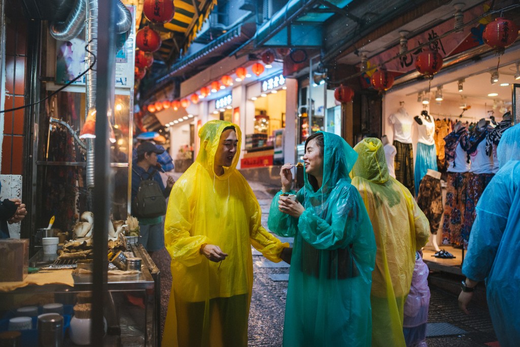 Image of Two happy young couple enjoying street food in Jiufen, Taiwan.