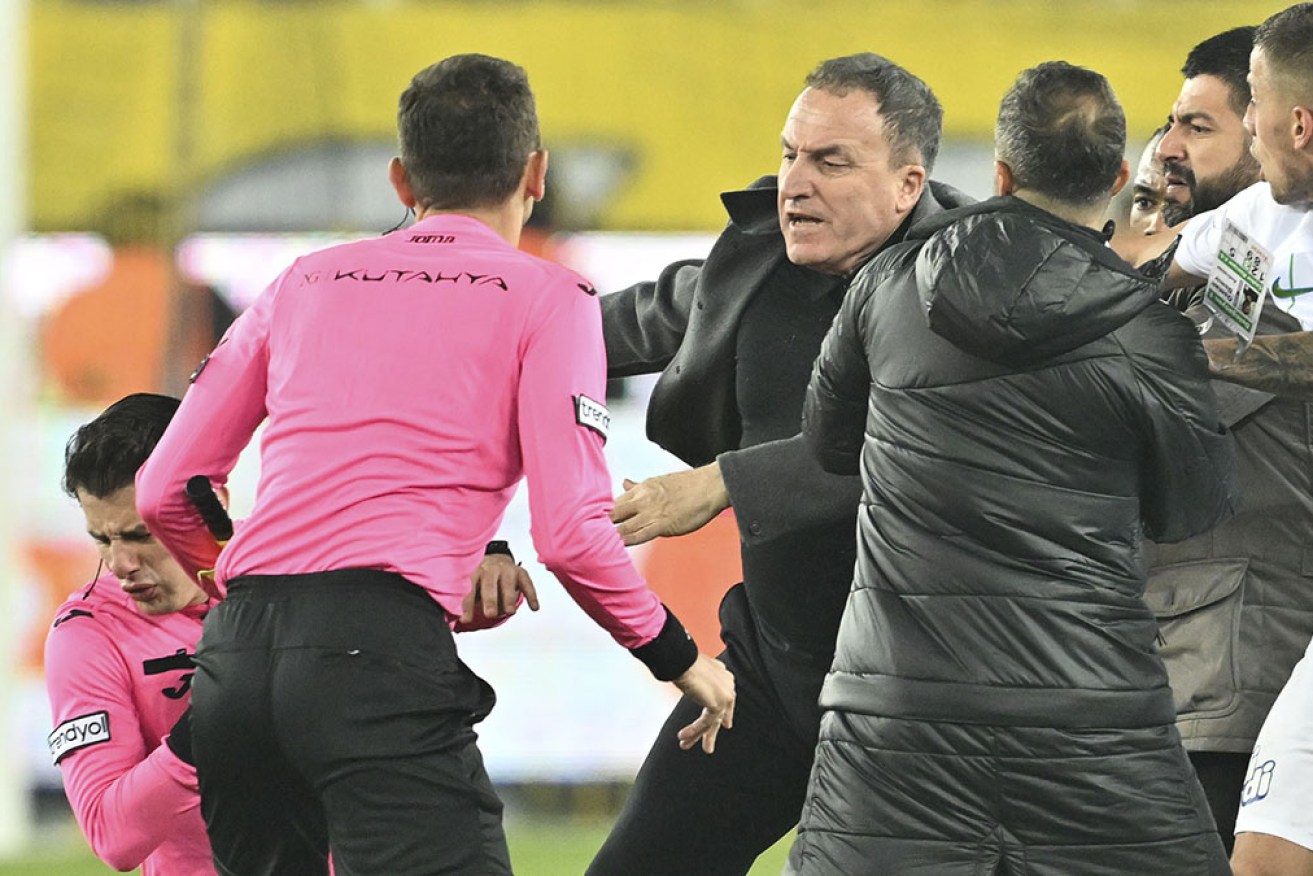 Referee Halil Umut Meler holds his face after being hit by Ankaragucu's president Faruk Koca.