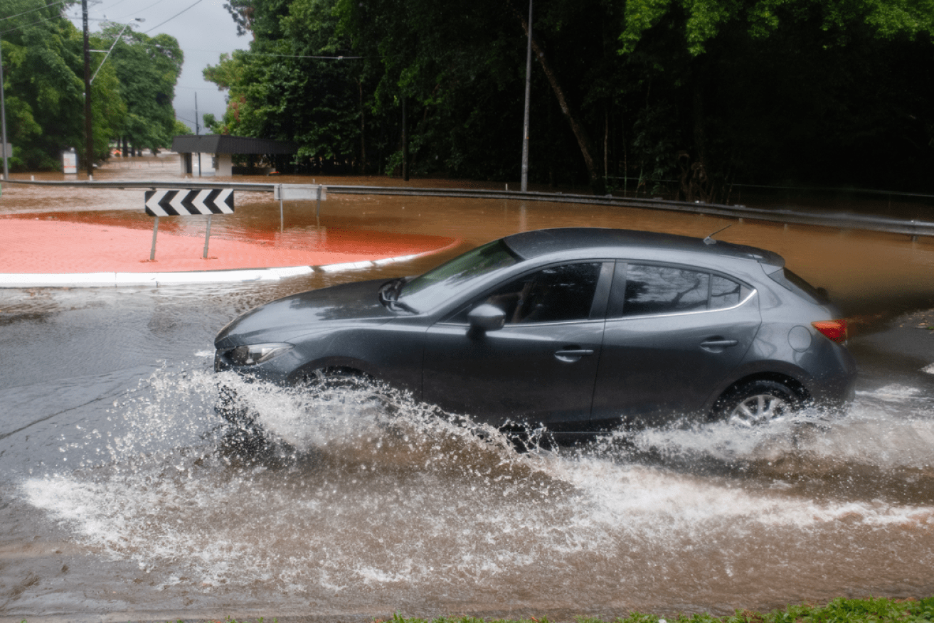 A driver does precisely what a driver shouldn't -- risking unseen deep water as the rain keeps falling.