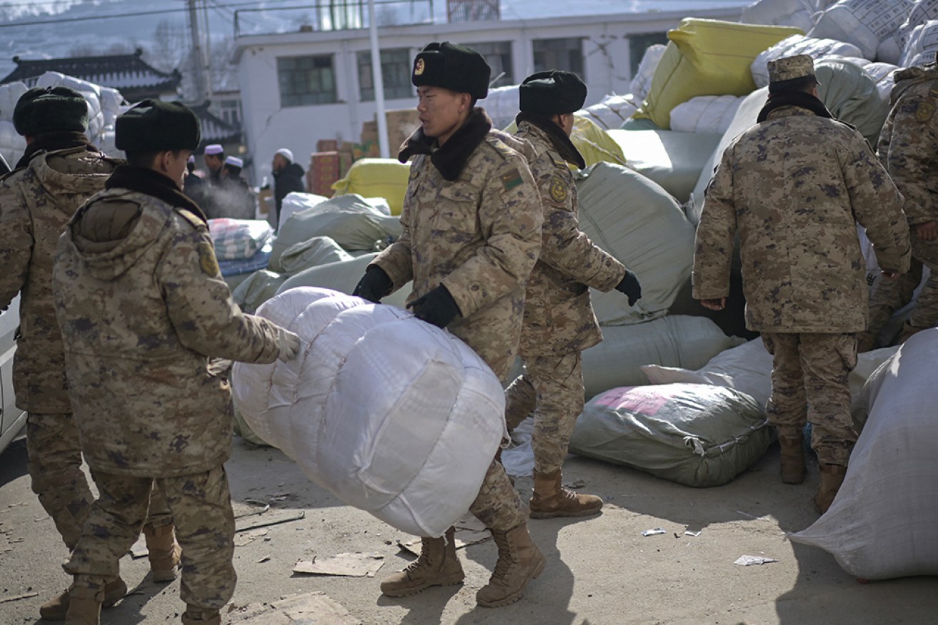 Military personnel work at an aid distribution center for earthquake victims in Liugou township.