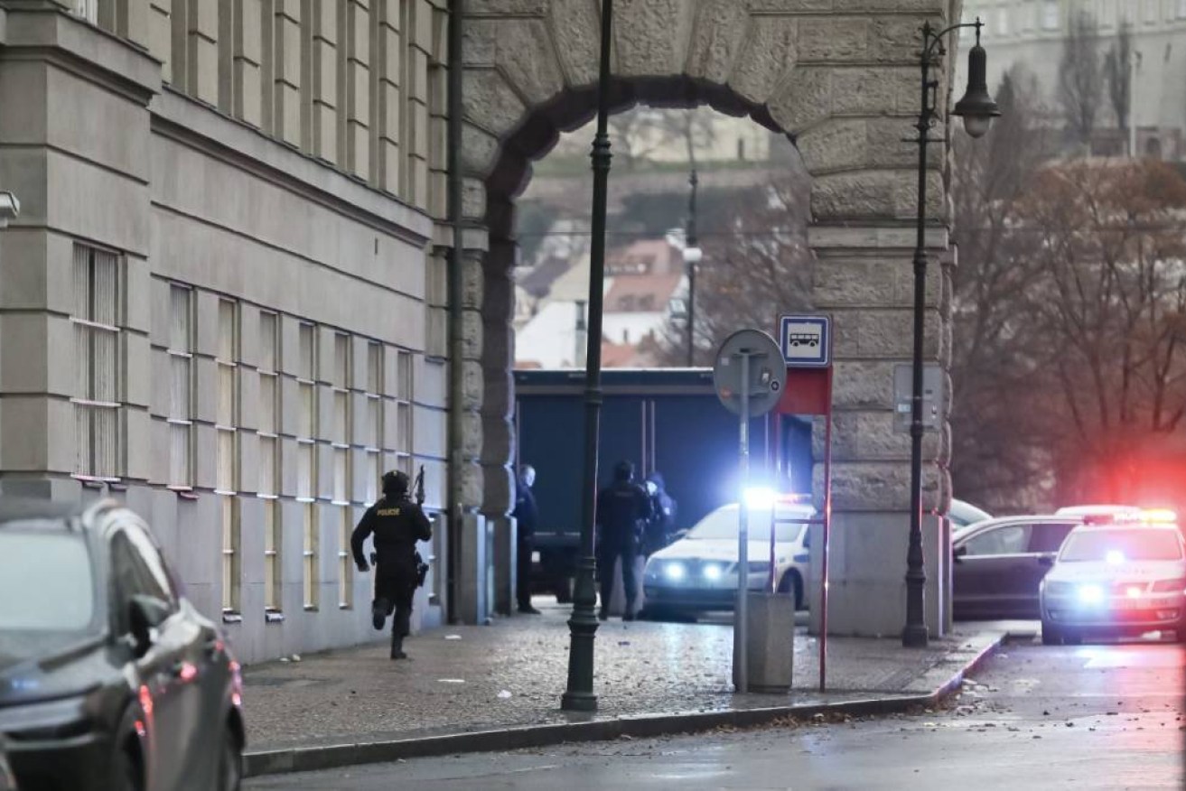 A police officer is seen running at the location of the shooting at Charles University in Prague.