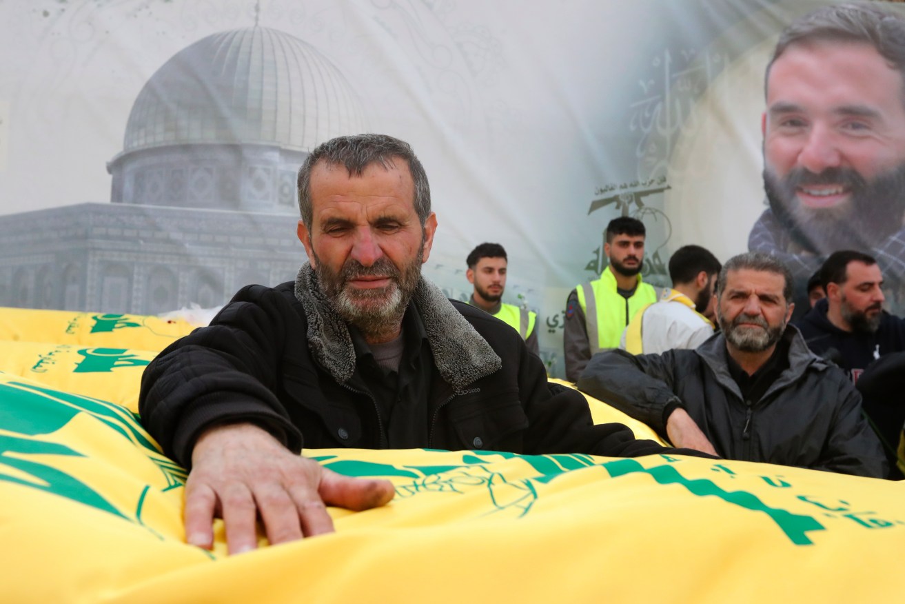 The brothers' father Ahmad Bazzi mourns over one of their coffin during their funeral processions, in Bint Jbeil, South Lebanon.