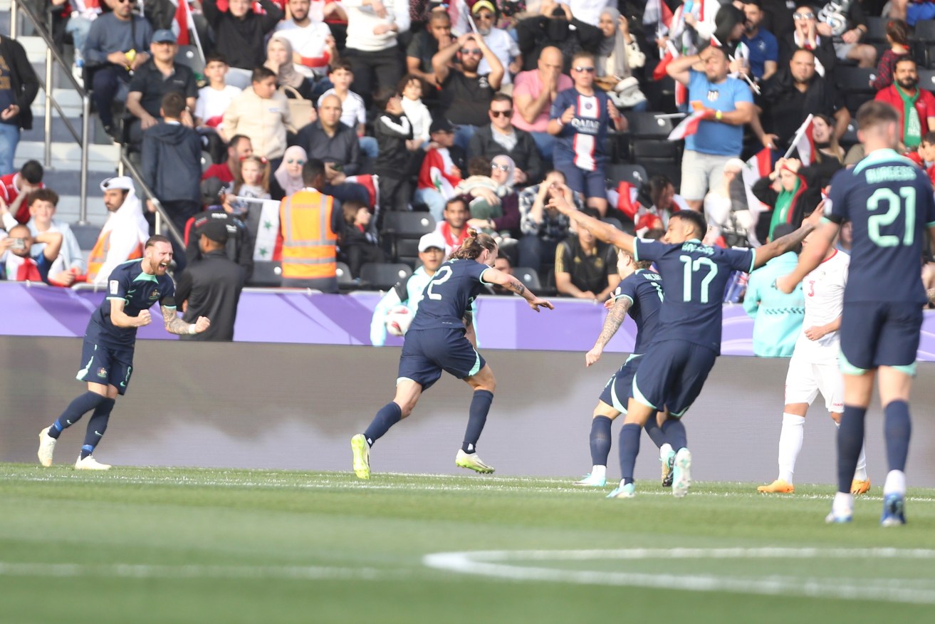 Jackson Irvine (centre) wheels away after scoring the opening goal in Australia's Asian Cup win.