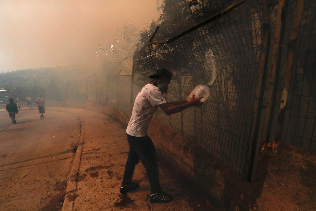 epa11124911 People fight the fire in the Las Palmas area during the forest fires affecting Vina del Mar, Valparaiso Region, Chile, 03 February 2024. The fires in the central region of Valparaíso have caused at least 19 deaths, according to official reports.  EPA/AILEN DIAZ