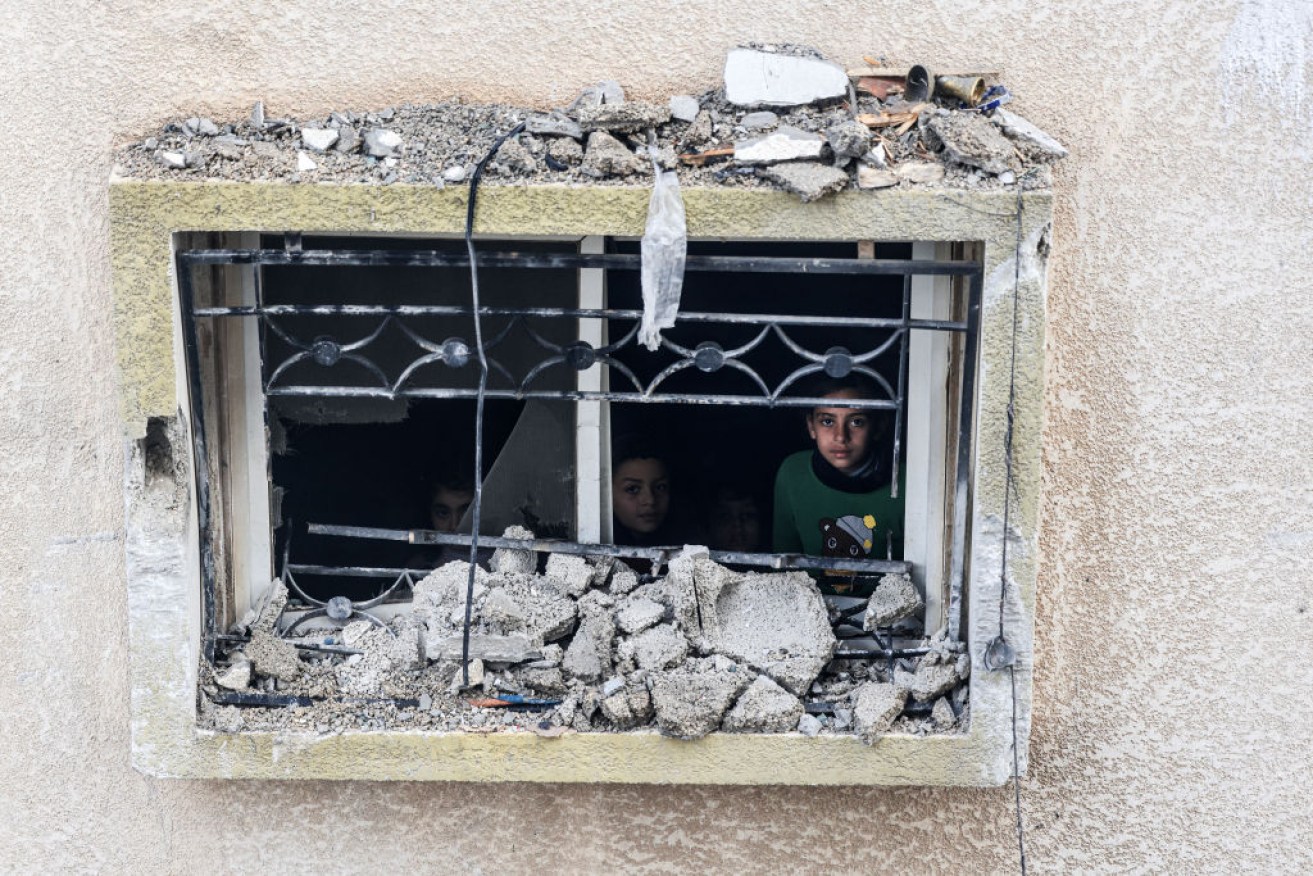 Children stare from the window of a damaged building, following Israeli bombardment in Rafah on February 9. 