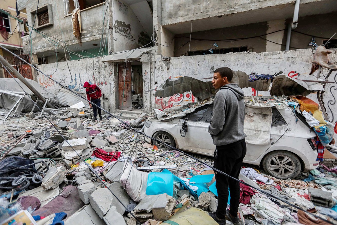 People inspect damage and recover items from their homes on Tuesday following Israeli air strikes in Gaza City. 