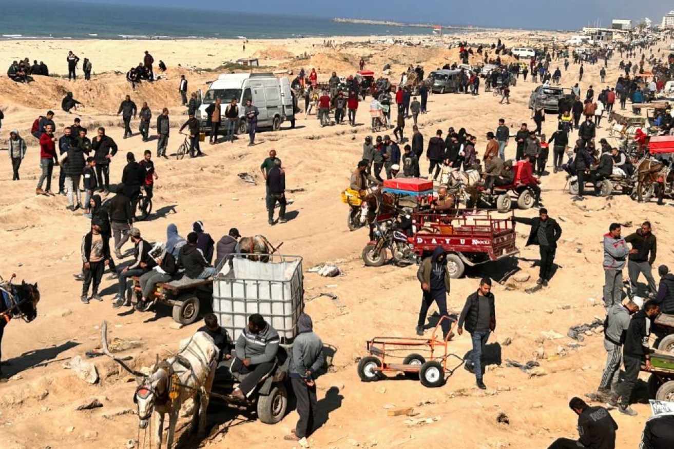 Palestinians surround aid trucks in northern Gaza in what officials described the day before as the first major delivery in a month.