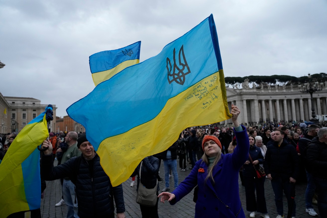 People wave Ukrainian flags in St.Peter's Square at the Vatican.