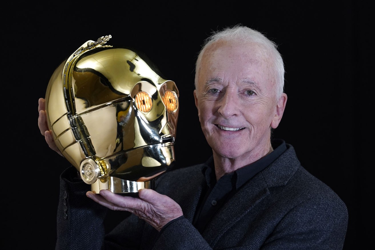 Actor Anthony Daniels poses with the C-3PO head from the 1977 film Star Wars: A New Hope.