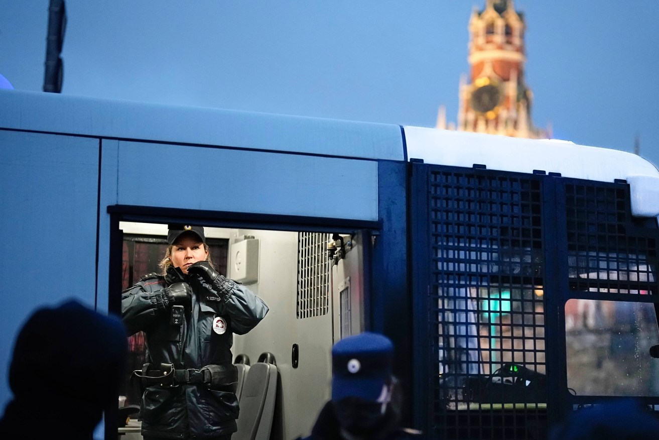 A police officer stands in a police bus with detained demonstrators during an anti-war protest near Red Square in Moscow, Russia, on Sept. 24, 2022. 