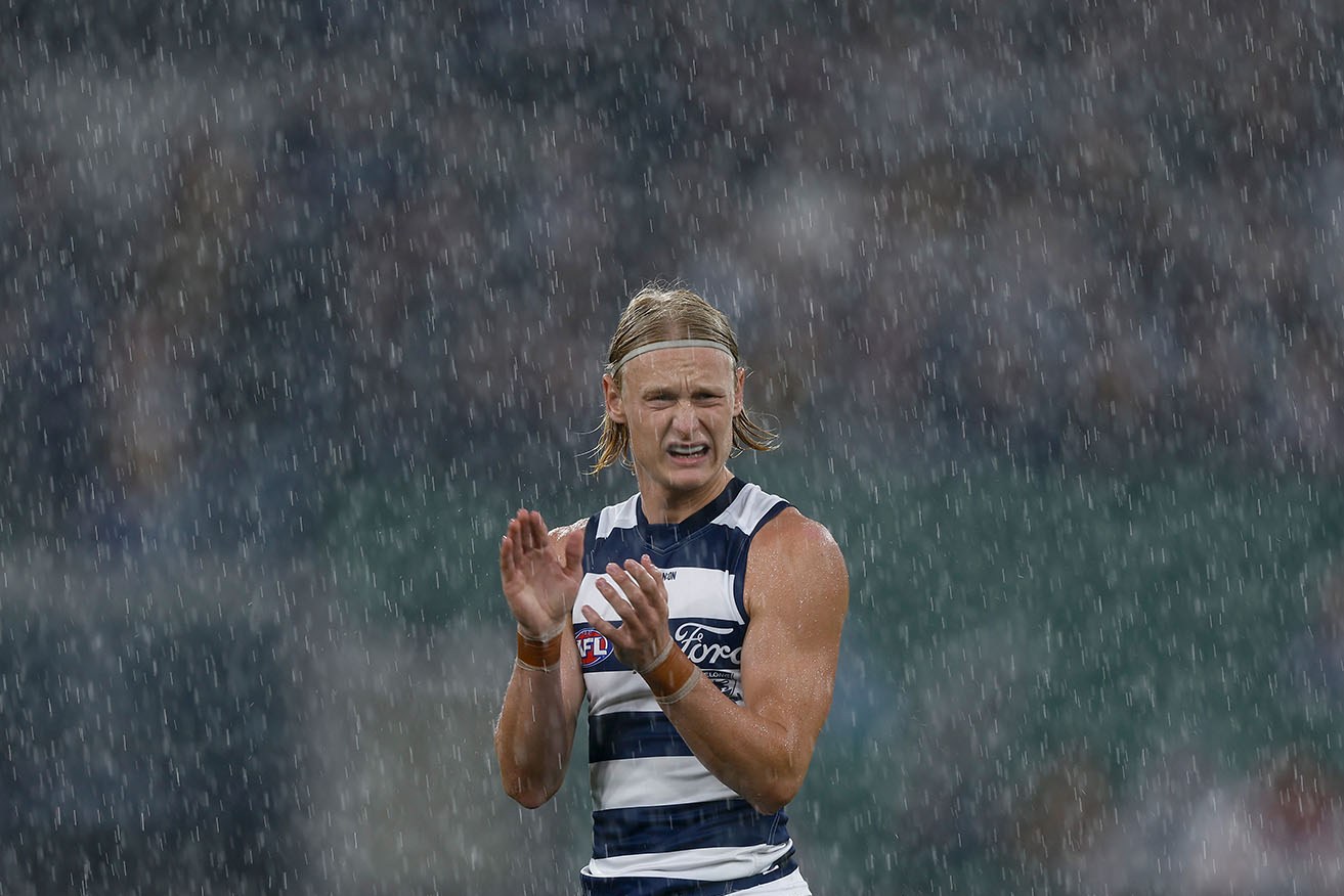 Geelong footballer Oliver Dempsey enjoys the rain at the MCG on Monday.
