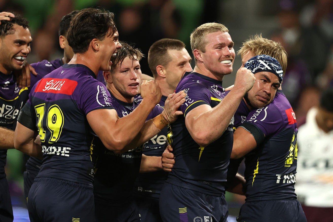 Melbourne celebrates the match-clinching try by Jahrome Hughes (helmet) against Brisbane on Thursday. 