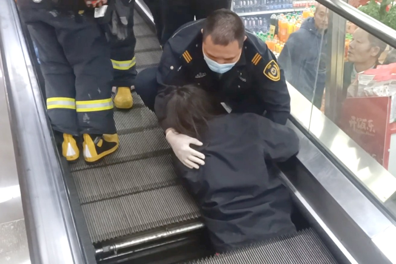 The woman was trapped in the moving walkway for half an hour before firefighters rescued her.