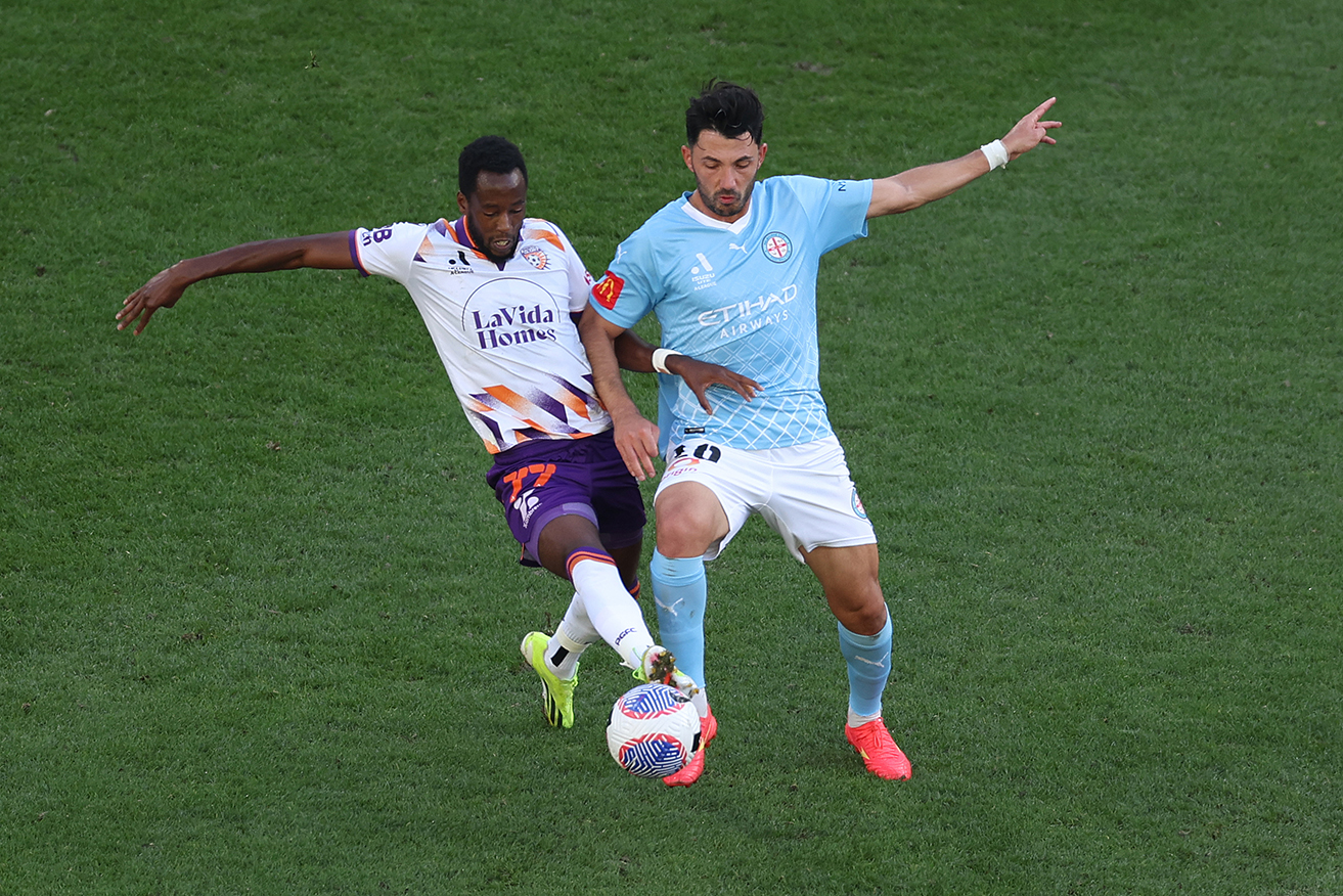 Perth’s Bruce Kamau challenges Melbourne City’s Tolgay Arslan in Sunday’s 8-0 win at AAMI Park. 