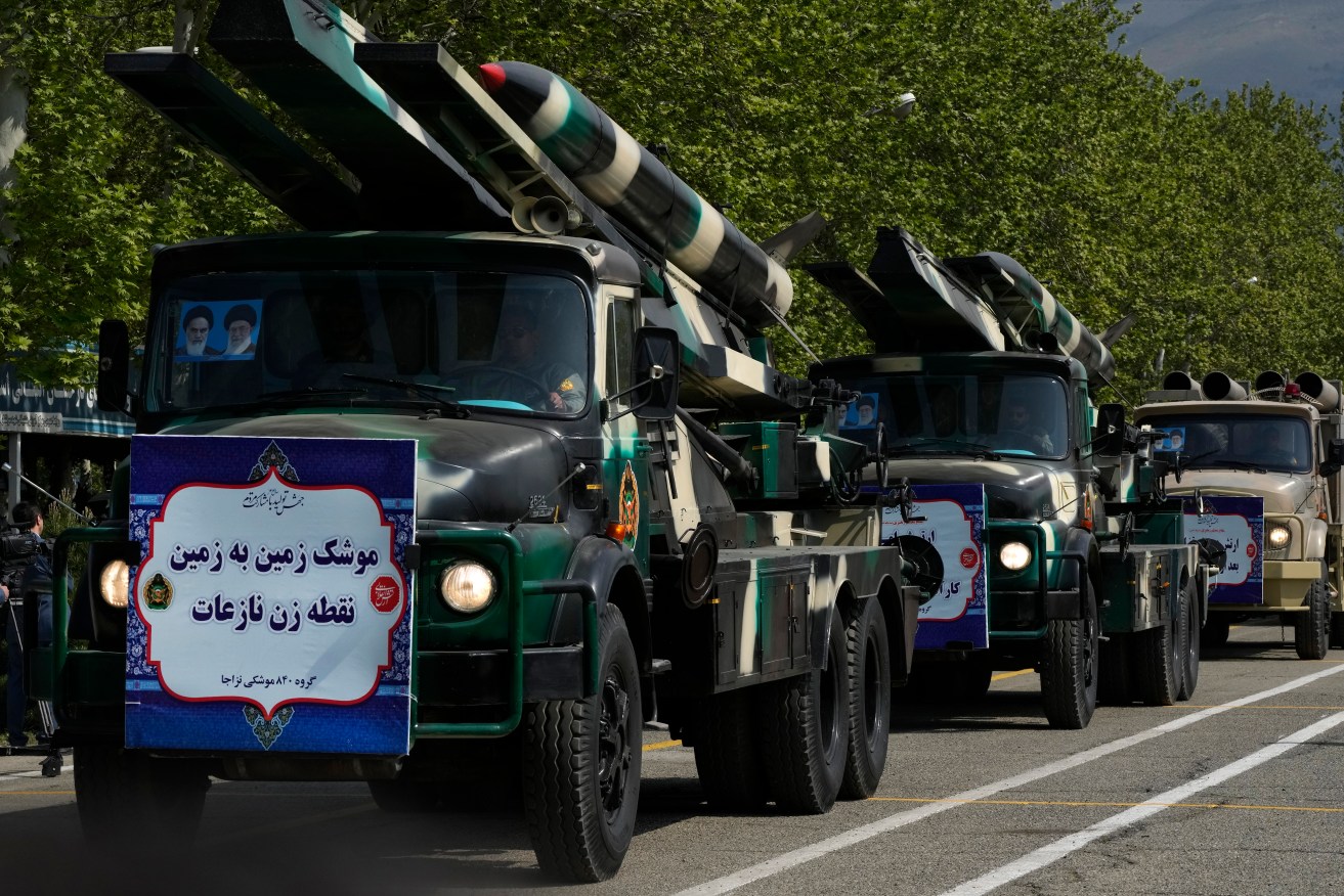 Missiles are carried on trucks during Army Day parade at a military base in northern Tehran, Iran, Wednesday, April 17, 2024. In the parade, President Ebrahim Raisi warned that the "tiniest invasion" by Israel would bring a "massive and harsh" response, as the region braces for potential Israeli retaliation after Iran's attack over the weekend. The banner on the truck reads in Farsi: "Surface-to-surface Nazeat precision missile." (AP Photo/Vahid Salemi)