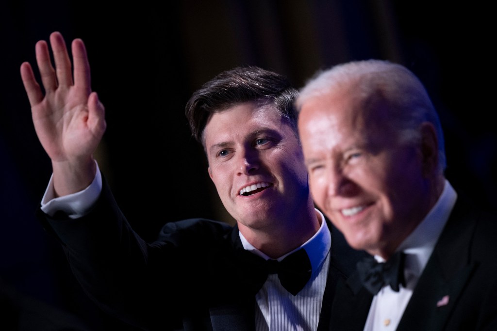 US comedian Colin Jost (L) waves while sitting with US President Joe Biden during the White House Correspondents' Association (WHCA) dinner at the Washington Hilton, in Washington, DC, on April 27, 2024. (