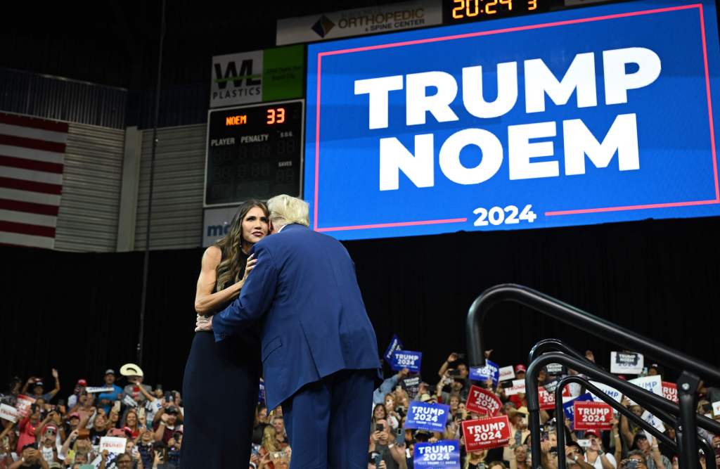 Former US president and 2024 Republican Presidential hopeful Donald Trump and South Dakota Governor, Kristi Noem hug on stage during the South Dakota Republican Party's Monumental Leaders rally at the Ice Arena at the Monument in Rapid City, South Dakota, 