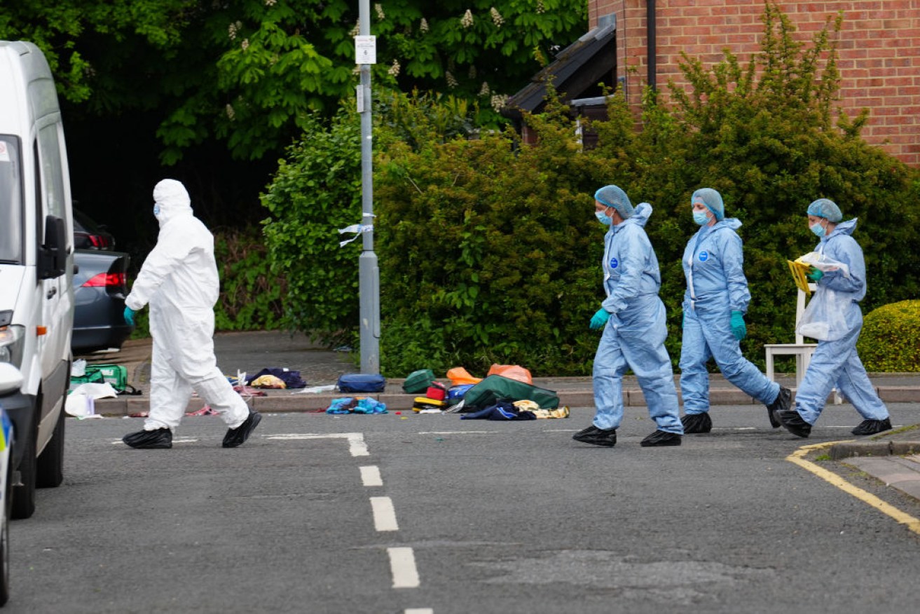 Forensic officers work the crime scene in Hainault, east London.
